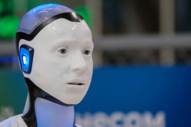 Aydınlatılmış insansı robot fuarda ileri teknoloji ve yenilik sergiliyor. Geleceksel tasarım, yapay zekayı vurguluyor.