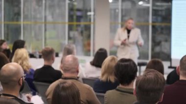 Profesyonel konuşmacı, çağdaş konferans odasında kurumsal sunum sırasında seyirciyi kendine çeker