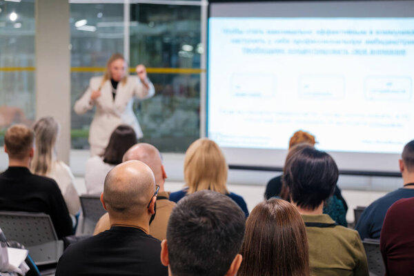 Докладчик ведет корпоративную презентацию в зале заседаний. Задействованная аудитория фокусируется на обучении и обсуждении.