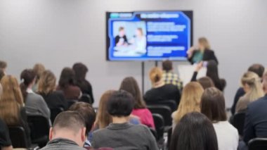 Bir grup profesyonel konferans ortamında sunumu dinliyor. Bağlı seyirciler içeriğe odaklandı.