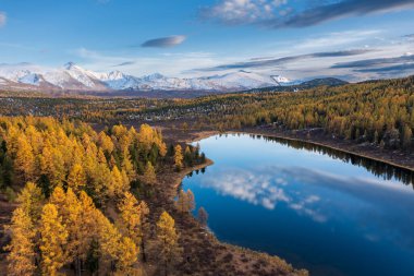 Sonbaharda büyüleyici Altai dağlarını yakalamak, sakin göl canlı yeşillikleri ve dingin doğayı yansıtıyor..