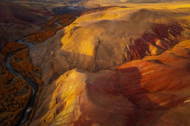 Drone view highlighting red and orange mountains, serene rivers, and autumn foliage in rugged terrain. Captivates with vibrant colors, natural contrast, and breathtaking wilderness scenery  clipart