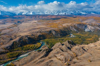 Altai Dağları 'nın sonbahar manzarası. Parlak ormanlar ve vadiden akan mavi nehirler..