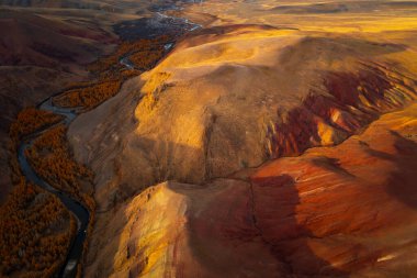 Rusya 'nın yukarısından gelen dolambaçlı bir nehri olan turuncu ve kırmızı renkli dağlar..