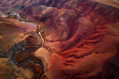 Scenic aerial view of rich mountain valley with winding river and dense forest, capturing vibrant autumn hues, erosion patterns, dramatic landscapes, offering unique glimpse of pristine wilderness clipart