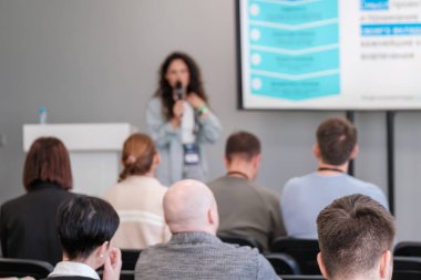 Hoparlörlü konferans kurulumu katılımcı kitleleri için anahtar noktaları vurguluyor. Etkileşimli sunum odaklanmayı ve öğrenmeyi teşvik eder.