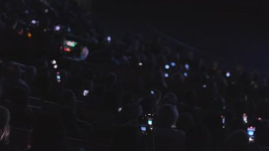 Karanlık oda seyircisi akıllı telefonlarda çekim yapıyor, canlı performans veya konferans kaydediyor.