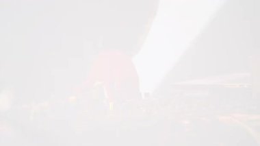 Canlı kırmızı ışıkta ses karıştırıcı kullanan bir DJ 'in dinamik görüntüsü. Müzik üretimi, eğlence ve yaratıcı ambiyansı canlı performans ortamında atmosfer enerjisini yakalıyor. 