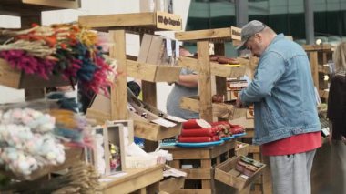 Kaliningrad, Rusya - 16 Haziran 2024: İnsanlar canlı kurumuş çiçeklerle çiftçi pazarındaki ahşap tezgahları keşfediyor ve üretiyorlar.