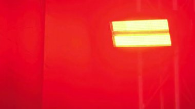 Parlak elektrik ışığı, canlı kırmızı arka planda sanatsal temalar için dinamik renkler sunar. Görüntü modern, göz alıcı tasarım sağlar, teknoloji için uygundur, sahne ışıklandırması