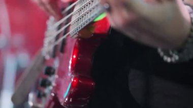 Canlı performans sırasında sahnede müzisyen tarafından çalınan kırmızı gitar. Canlı ve sanatsal..