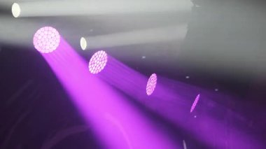Puslu bir ortamda yansıyan mor sahne ışıkları, konser sahneleri için mükemmel..