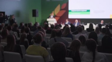 Bir iş etkinliğinde sahnede hoparlörleri dinleyen sayısız katılımcıyla konferans yeri. Profesyonel ortamdaki öğrenme, işbirliği ve etkileşimi yakalar.