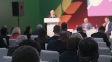 Seyirciler profesyonel konferans ortamında katılımcılar arasındaki ticari bilgi alışverişini vurguladılar.