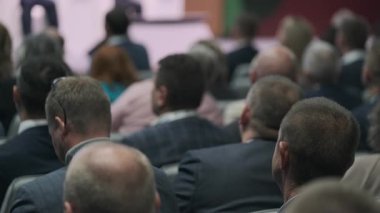 Seminerde ya da konferansta kalabalıklar, kameraya bakan insanlar, özenli seyirciler..