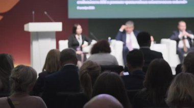Uzman katılımcıların sahnede konuları tartıştığı profesyonel bir konferans..
