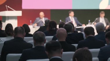 Organize iş konferansına katılanlar profesyonel konuları ve zorlukları tartışan konuşmacı panelini izliyorlar