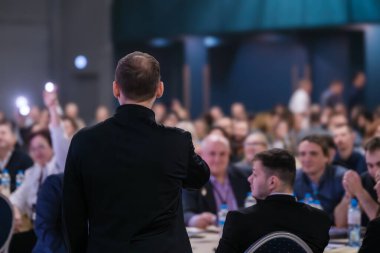 Kurumsal bir seminerde özenli bir konuşmacı, önemli konuları tartışıyor..