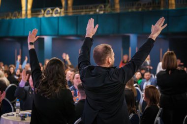 Etkinliğe katılanlar ellerini kaldırarak, bağlılığı ve etkileşimi teşvik ederek coşkularını dile getiriyorlar.
