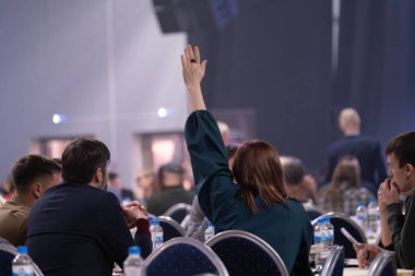 İzleyici iş toplantısına veya eğitim seminerine katılmak için elini kaldırıyor.