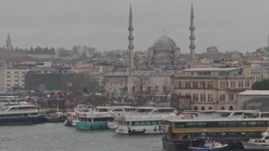 İstanbul 'da minareler, hareketli limanlar ve bulutlu atmosferli ikonik cami manzarası.