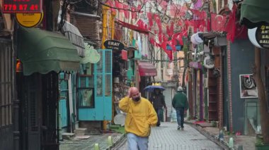İstanbul, Türkiye - 1 Nisan 2025: Renkli cephelerle, Türk kültür unsurlarıyla, yağmurlu atmosferle, yayalarla canlı dekore edilmiş kentsel cadde.