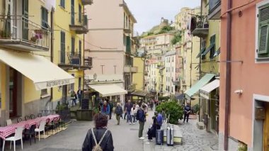 Cinque Terre, İtalya - 10 Kasım 2024: İnsanlar şehri keşfediyor ve canlı İtalyan sokak sahnelerinde açık hava kafelerinin keyfini çıkarıyorlar 