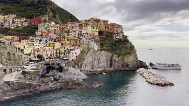 İtalya 'nın Cinque Terre kentindeki İtalya kıyı cazibesini tasvir eden büyüleyici deniz manzaralı bir uçuruma tünemiş renkli evler.