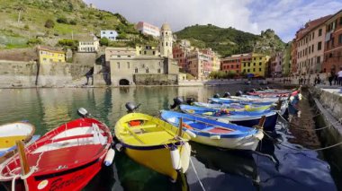 Cinque Terre, İtalya - 10 Kasım 2024: Resimli Vernazza kasabasında renkli balıkçı tekneleri ve binalarıyla canlı liman sahnesi