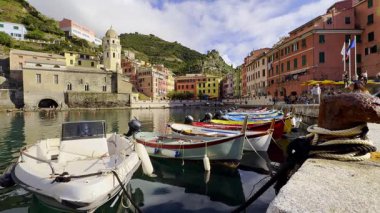 Renkli balıkçı tekneleri ve binaları ile canlı liman sahnesi Cinque Terre, İtalya 'daki Vernazza kasabasında