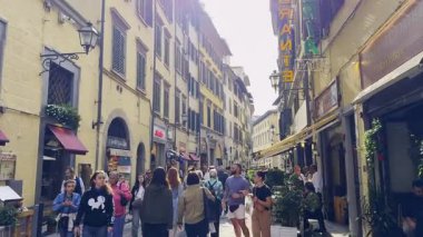 Florence, İtalya - 10 Kasım 2024: Floransa 'nın hareketli caddesinde yürüyen turistler yerel mimari, dükkanlar ve kafeler