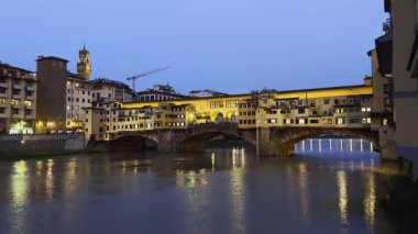 Floransa 'da akşam saatlerinde Arno' nun mimari ve yansımalarını gösteren tarihi Ponte Vecchio kitabı.