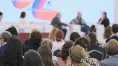 Konferansa katılanlar bilgilendirici ve etkileşimli bir panel oturumu sırasında konuşmacılarla iletişime geçerler.