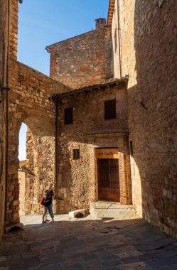 Arezzo, İtalya - 15 Nisan 2025: Bir sanat galerisinin yakınındaki eski kasaba sokağında birbirlerine aşık genç bir çift