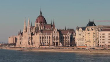 Güzel nehir kenarı mimari simgesi açık güneşli gökyüzünün altında karmaşık neo-gotik tasarım sergiliyor..