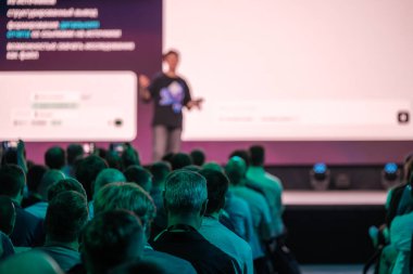 İzleyiciler bilgilendirici bir konferans sırasında bir konuşmacıyı dikkatle dinliyor