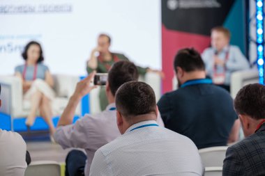 Seyirciler dikkatle bir iş seminerine katılıyorlar. Bilgilendirme oturumunda profesyoneller görev aldı.