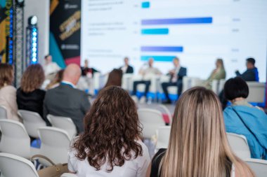 Profesyonel bir konferans sırasında katılımcılar bir panel tartışmasında dikkatle otururlar..