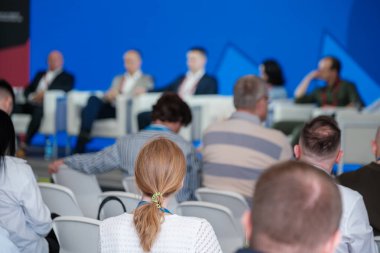 İş konferansına katılan profesyonel seyirciler panel tartışması ve sunumuna odaklanıyor.