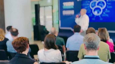 Katılım ve öğrenmeyi vurgulayan sunum sırasında seyirciye ve konuşmacıya odaklı profesyonel bir konferans ortamının net görüntüsü