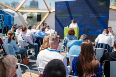 Modern bir ortamda profesyonel bir seminere katılan bir grup insan. Büyümeye ve bilgi paylaşımına odaklan.