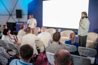 Konuşmacılarla yapılan bir konferansta sunum seyirciyi profesyonel tartışmalara çekiyor