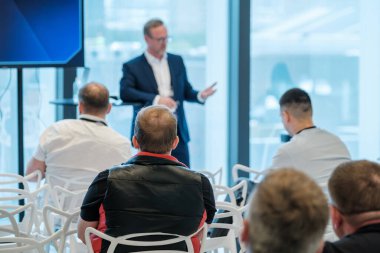 Parlak modern konferans salonunda katılımcılar ve konuşmacılarla yapılan iş etkinliği.