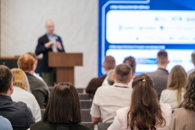 Seminere katılanlar dijital ekranın yanında hoparlörlü bir sunum dinliyorlar. Konferans ayarları.