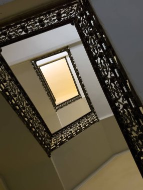 Süslü demir merdiven tasarımı yukarı doğru spiraller ve karmaşık dekoratif desenler sergiliyor.