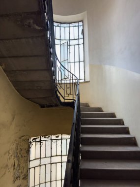 Endüstriyel merdivenler, kıvrımlı metal korkuluklar, geniş pencereler ve eski duvarlar klasik cazibe yaratıyor. Mimari ayrıntıları, kentsel tasarımı ve eski binadaki eski kırsal estetiği yakalar.