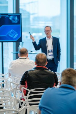 Profesyonel konuşmacı, modern bir iş seminerinde görsel ortamda seyirciye sunum yapıyor..