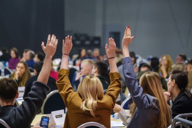 Elleri havada bir toplantıya veya seminere katılanlar, aktif bir katılım sergiliyor