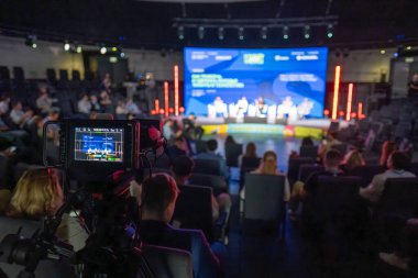 Konferans etkinliği kamera odağı ile çekildi, seyirci sahnede panel hoparlörlerine katılıyor