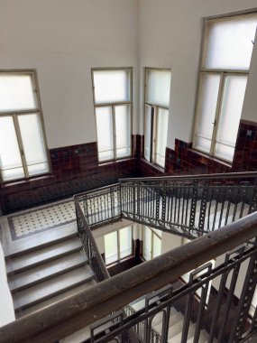 Sessiz merdiven boşluğu dekore edilmiş demir parmaklıklar kartonpiyer duvarlar eski bina cazibesini çağrıştırıyor